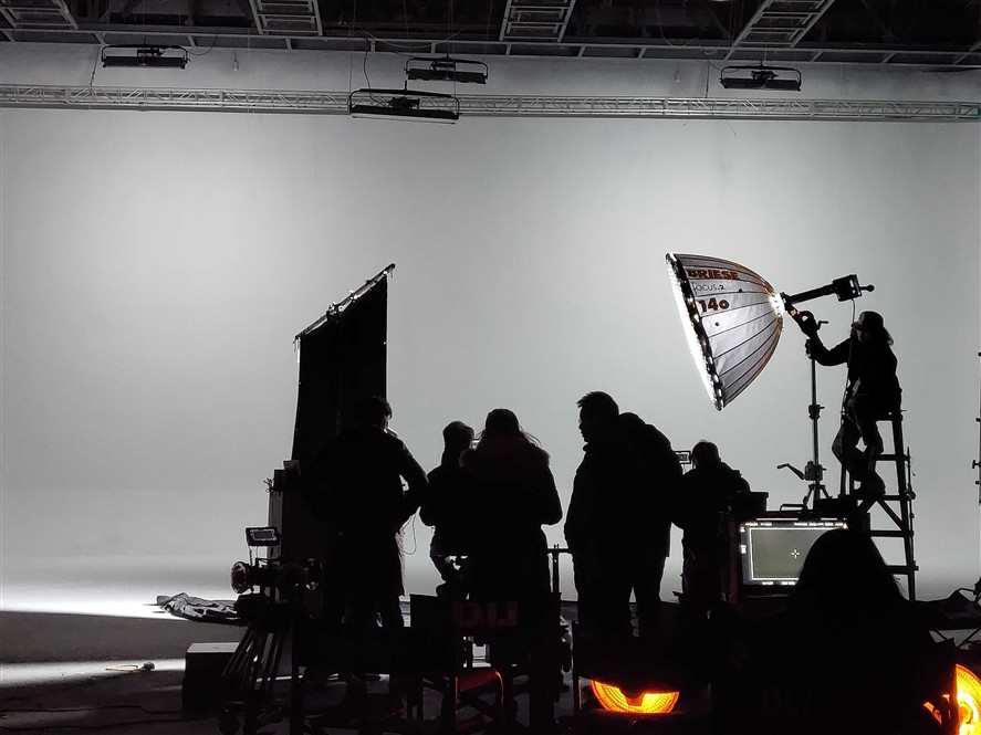 Indoor Beijing production setup with crew, lighting, and camera gear on a studio stage