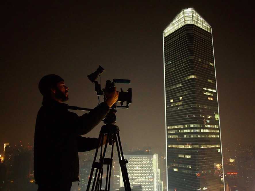 Beijing filming crew at night with city lights in the background